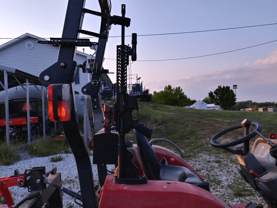 AR style rifle with Collapsible butt stock on Gun Rack Mounting Bracket on a Massey Ferguson 1739